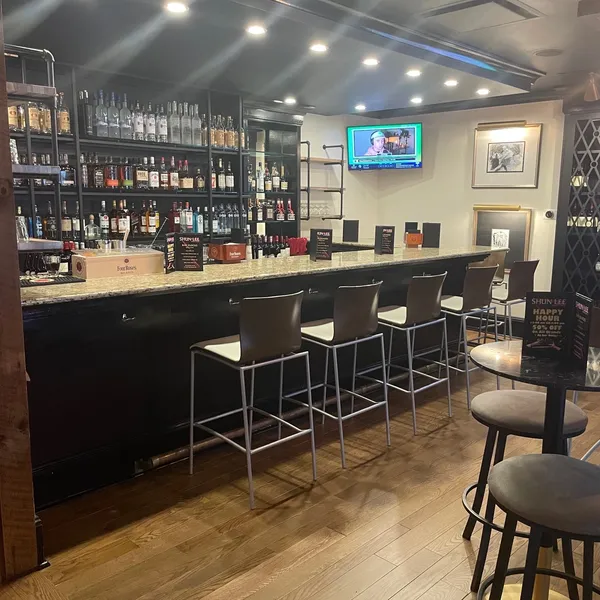 Bar counter with liquor display and bar stools at Shun Lee, a Chinese Restaurant in Lexington